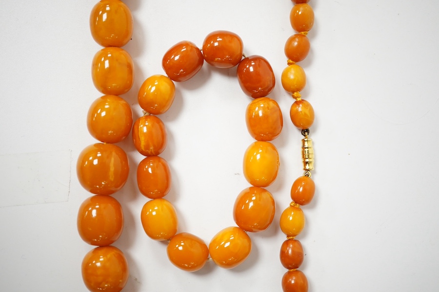 A single strand graduated amber bead necklace, 70cm, gross weight 67 grams, together with an amber bead bracelet, gross weight 20 grams. Condition - poor to fair